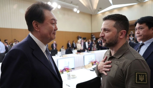 ▲ 윤석열 대통령이 21일 히로시마 그랜드 프린스 호텔에서 열린 G7 정상회의 확대세션에 참석해 볼로디미르 젤렌스키 우크라이나 대통령과 손을 잡고 대화하고 있다. ⓒ대통령실