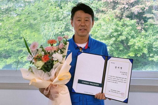 ▲ CJ대한통운 택배기사 김흔수씨가 감사장을 받고 기념사진 촬영을 하고 있다. ⓒCJ대한통운