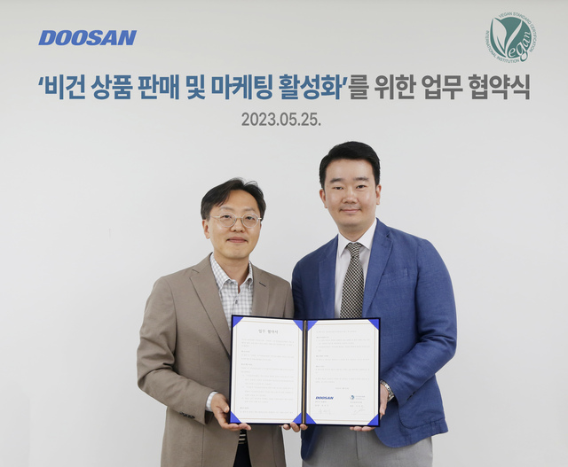 ▲ (왼쪽부터)송석기 ㈜두산 유통BU 대표와 이인성 비건표준인증원 원장이 ‘비건 상품 판매 및 마케팅 활성화’를 위한 업무협약(MOU) 체결 후 기념사진을 촬영하고 있다. ⓒ㈜두산