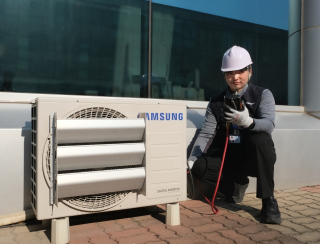 ▲ 삼성전자서비스 엔지니어가 '에어컨 사전점검'을 신청한 고객의 실외기를 점검하고 있다. ⓒ삼성전자서비스