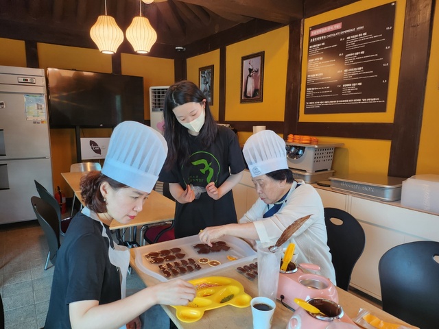 ▲ 관광객 2명이 제천 청풍 본정스쿨 초콜릿체험카페에서 초콜릿 체험을 하고 있다.ⓒ본정스쿨 초콜릿카페