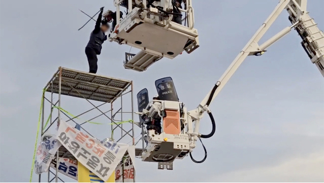 ▲ 전남경찰청은 지난 5월31일 전남 광양시 금호동 포스코 광양제철소 인근 도로에 높이 7ｍ 망루를 설치하는 등 불법집회를 벌인 한국노총 금속노련 관계자를 붙잡아 조사하고 있다고 밝혔다. 사진은 고공 농성 중인 조합원과 사다리차에 올라탄 경찰이 대치하는 모습.ⓒ전남경찰청 제공