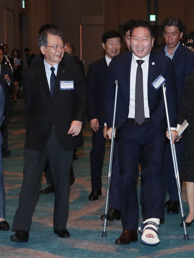 목발을 짚은 최태원 대한상의 회장(오른쪽)과 고바야시 켄(왼쪽) 일본상의 회장이 행사장으로 입장하고 있는 모습.ⓒ대한상공회의소