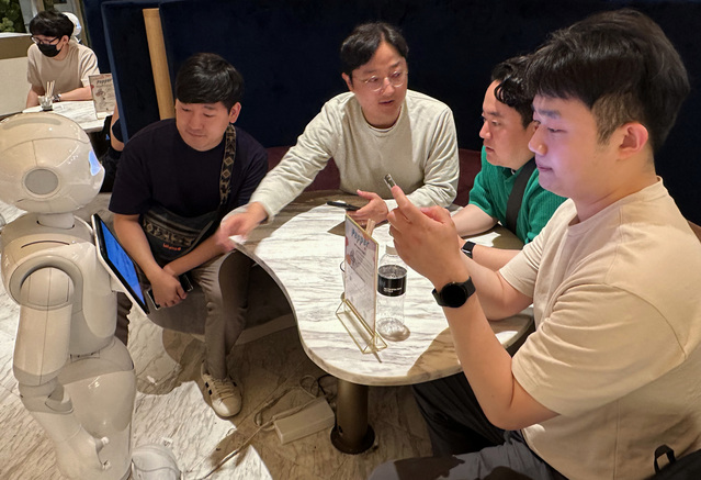 ▲ 프로그램에 참여한 직원들이 일본 도쿄의 PEPPER PARLOR 카페에서 서비스 로봇 이용을 체험하고 있는 모습ⓒLG유플러스