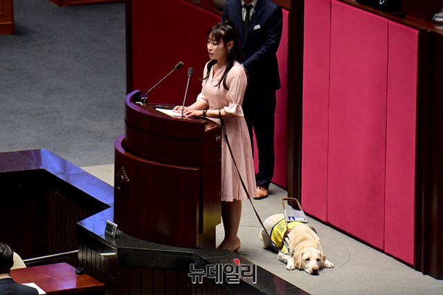 ▲ 김예지 국민의힘 의원과 시각장애인 안내견 조이가 지난 14일 오후 국회에서 열린 본회의 교육·사회·문화 대정부질문에서 발언하기 위해 단상에 자리하고 있다. ⓒ이종현 기자