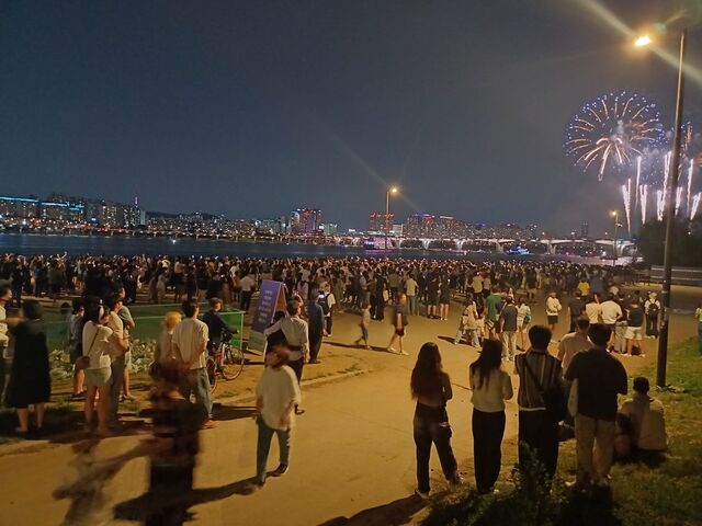 ▲ 축제에 참가한 시민들이 BTS 데뷔 10주년을 기념하는 불꽃놀이를 감상하고 있다. ⓒ김성웅 기자