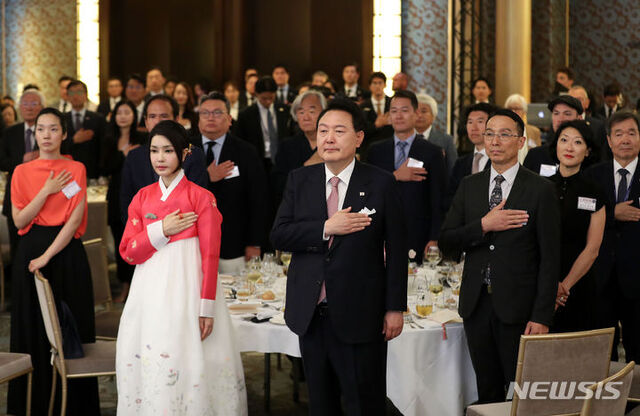 ▲ 윤석열 대통령과 부인 김건희 여사가 19일(현지시간) 파리 한 호텔에서 열린 프랑스 동포 초청 만찬 간담회에서 국기에 대한 경례를 하고 있다.ⓒ뉴시스