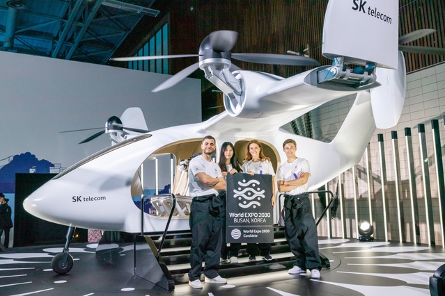▲ 파리 인근 이시레물리노시 스포츠센터에 마련된 행사장 찾은 국제박람회기구 회원국 대표단이 UAM을 체험하는 모습ⓒSK텔레콤