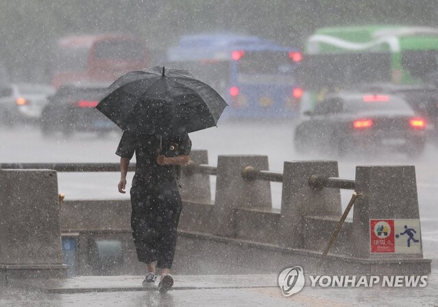 지난 14일 오후 서울 시내에서 시민들이 우산을 쓴 채 이동하고 있다ⓒ연합뉴스
