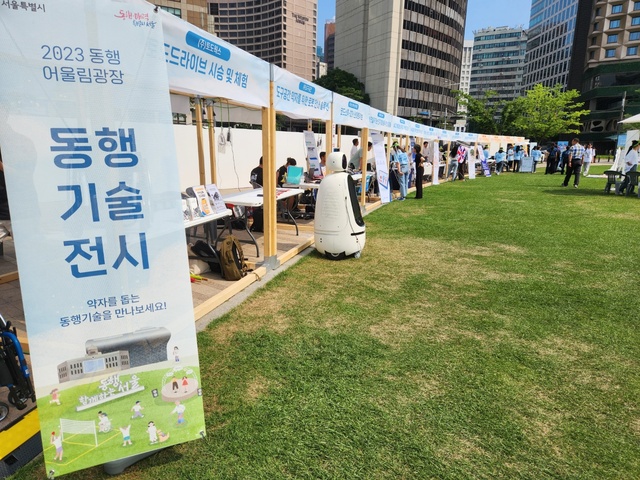 ▲ '동행 어울림광장' 행사가 23일 열린 가운데 '동행기술 전시' 부스에 자리를 마련한 10개 기업이 시민들이 여러 제품을 체험할 수 있도록 돕고 있다. ⓒ진선우 기자