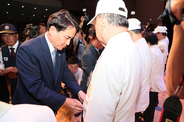 ▲ 김진태 강원특별자치도지사가 25일 6‧25전쟁 제73주년 기념식에 참전용사에게 제복을 입현 준 뒤 단추를 담가주고 있다.ⓒ강원특별자치도