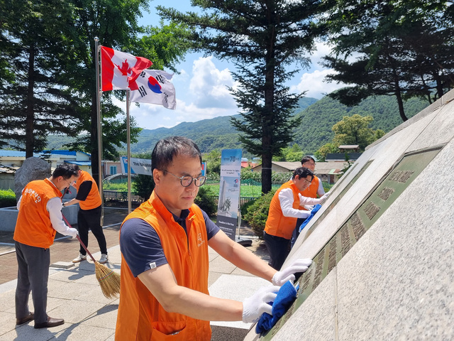 ▲ 한화오션 직원이 캐나다 전투기념비에 환경정화 활동을 하고 있다. ⓒ한화오션