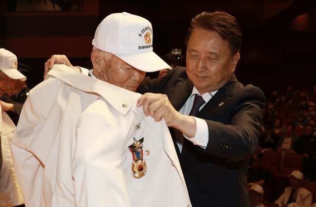 ▲ 김영환 충북도지사가 25일 청주예술의 전당에서 열린 6‧25전쟁 제73주년 기념식에서 참전 용사에게  ‘영웅의 제복’을 입혀주고 있다.ⓒ충북도