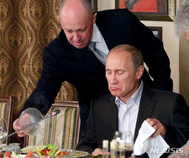 ▲ 지난 2011년 11월 11일(현지시각) 모스크바 외곽의 한 식당에서 저녁 식사 중 바그너 그룹 수장 예브게니 프리고진(왼쪽)이 블라디미르 푸틴 러시아 대통령에게 음식을 건네고 있는 모습. ⓒAP/뉴시스