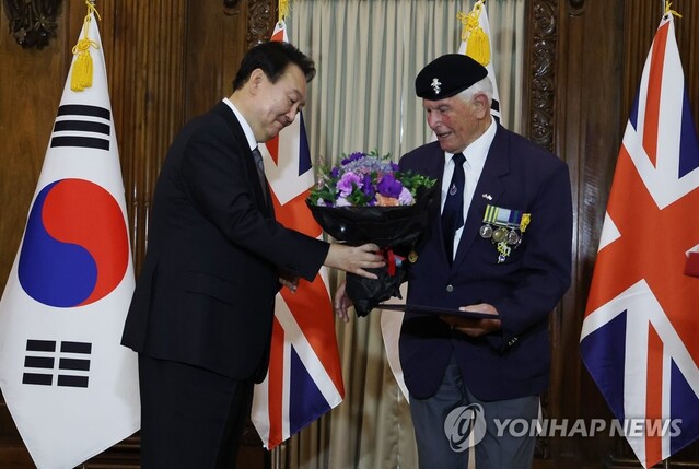 ▲ 윤석열 대통령이 19일(현지시간) 영국 런던 한 호텔에서 빅터 스위프트 영국 한국전 참전용사협회 회장에게 국민포장을 수여한 뒤 꽃다발을 전달하고 있다. 빅터 스위프트 회장은 1934년생으로 당시 영국 육군 왕립 전자기계 공병군단 소속으로 한국전에 참전했다.2022.9.19ⓒ연합뉴스