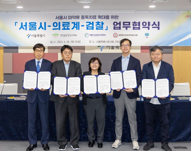 ▲ 29일 오전 서울시청에서 진행된 서울시 마약류 중독치료 확대를 위한 서울시-의료계-검찰 업무협약식에 참석한 (왼쪽부터) 신준호 서울중앙지방검찰청 부장검사, 강현구 대한정신건강의학의사회 법제이사, 박유미 서울시 시민건강국장, 이해국 한국중독정신의학회 이사장, 이동우 대한신경정신의학회 정책연구소장이 기념촬영하고 있다. ⓒ사진제공=서울시