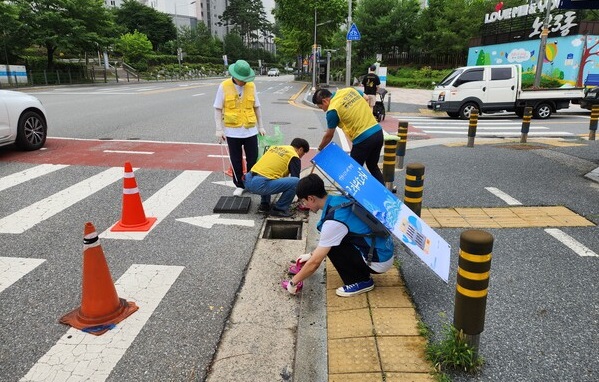 ▲ 대전 유성구 노는 3동이 지난 1일 자원봉사단체 ‘청정보안관’과 함께 여름 장마철 침수피해 예방을 위해 빗물받이의 오염물 제거 캠페인을 진행했다.ⓒ대전유성구