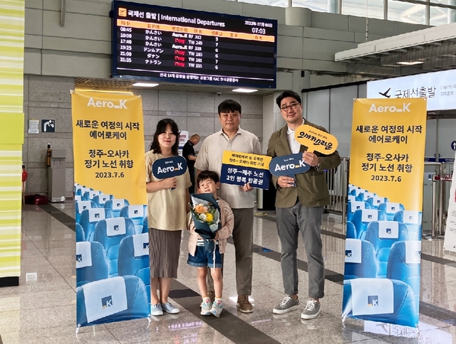▲ 에어로케이 오사카행 첫 편 1호 승객 가족이 에어로케이 김상보 본부장과 기념사진을 찍고 있다. ⓒ에어로케이