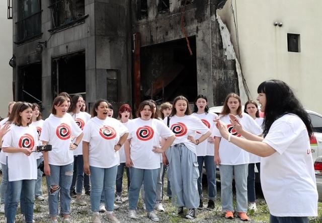 ▲ 우크라이나 보그닉 소녀합창단이 지난 3일 오후 대형산불로 불에 탄 경포의 한 펜션 앞에서 공연하고 있다.ⓒ연합뉴스