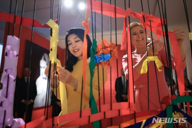 ▲ 윤석열 대통령 부인 김건희 여사와 안제이 두다 폴란드 대통령 부인 아가타 코른하우저 두다 여사가 13일(현지시간) 바르샤바 와지엔키 박물관을 방문해 전시를 관람하며 프리다 칼로의 시그니처 색상을 사용해 리본을 구성하는 체험을 하고 있다. (공동취재) ⓒ뉴시스