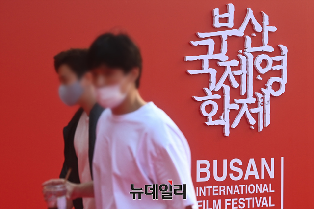 ▲ 2021 부산국제영화제(BIFF) 개막을 앞둔 지난 2021년 10월 6일 오후 부산 해운대구 영화의전당 야외 상영관에서 자원봉사자가 좌석에 거리두기를 표시하는 영화 포스터를 부착하고 있다. ⓒ뉴데일리DB