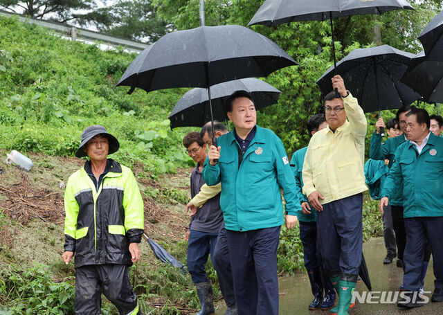 ▲ 집중호우 피해 현장 방문에 나선 윤석열 대통령이 18일 충남 공주 탄천면 피해 비닐하우스를 살펴보고 있다.ⓒ뉴시스