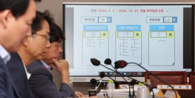 ▲ 2024년도 최저임금이 9천860원으로 결정됐다. 19일 새벽 세종시 정부세종청사 최저임금위원회 회의실 모니터에 표결 결과가 게시돼 있다. 박준식 위원장(왼쪽 두번째)을 포함한 공익위원들이 회의실에 자리하고 있다. ⓒ연합뉴스