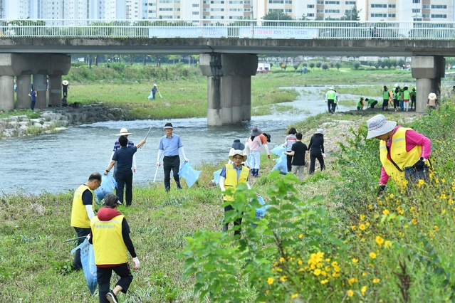 ▲ 경산시(시장 조현일)는 21일 시민 휴식공간인 남천강변에서 시 소속 공무원 600여 명과 민간단체 회원이 참석한 가운데 최근 집중호우로 발생한 피해복구 작업을 대대적으로 했다.ⓒ경산시