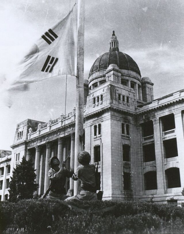 ▲ 대한민국 국군이 1954년 중앙청 앞에서 서울 수복 기념으로 태극기 게양을 재연하고 있다. ⓒ국가기록원