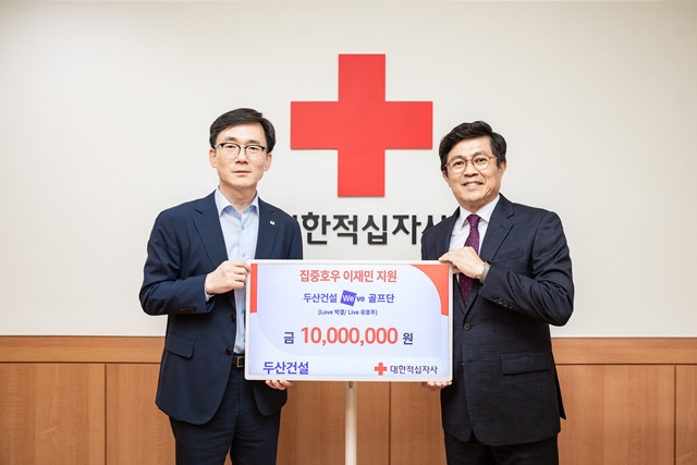 ▲ 이상천 대한적십자가 사무총장(좌)과 오세욱 두산건설 상무가 전달식에서 기념촬영을 하고 있다. ⓒ두산건설