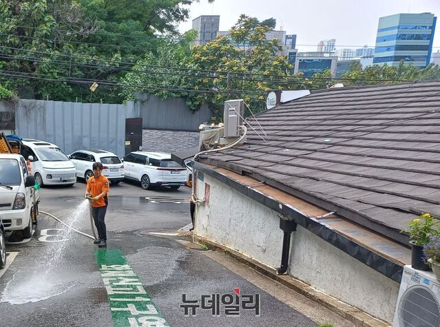 ▲ 소방대원이 쪽방촌 골목의 열기를 식히기 위해 호스로 물을 뿌리고 있다. ⓒ김성웅 기자