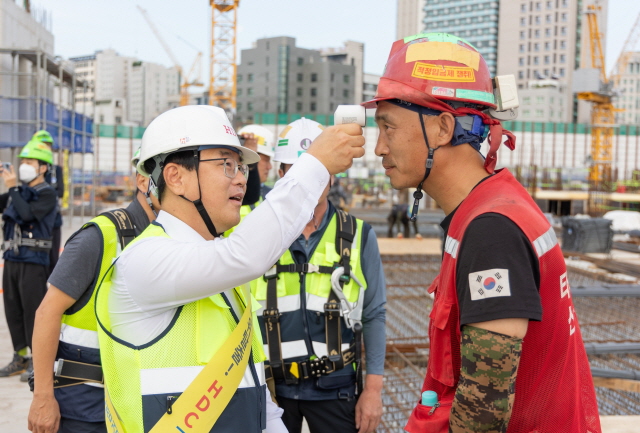 ▲ 김회언 HDC현대산업개발 대표(좌측)가 현장근로자의 건강 상태를 확인하고 있다. ⓒHDC현대산업개발