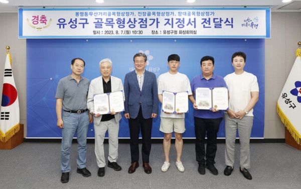 ▲ 7일 유성구 골목형상점가 지정서 전달식이 개최된 가운데 정용래 청장(왼쪽, 세 번째)과 참석자들이 기념촬영을 하고 있다.ⓒ유성구