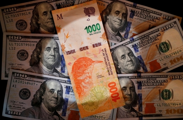 ▲ 100달러짜리 미국 달러 지폐 위에 놓인 아르헨티나 페소 지폐 ⓒ연합뉴스