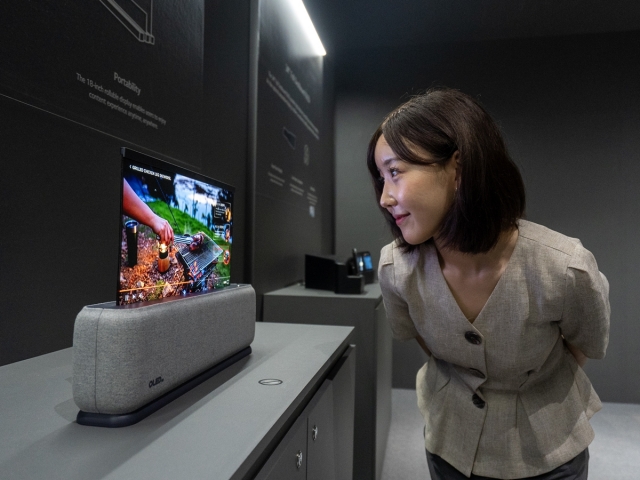 ▲ 23일 부산 벡스코에서 열린 ‘IMID 2023'에서 관람객이 LG디스플레이의 18인치 차량용 롤러블 OLED 패널을 살펴보고 있다. ⓒLG디스플레이