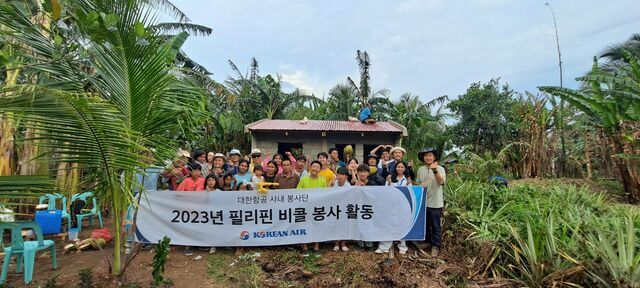 ▲ 대한항공 사내 봉사단체 '연합신우회'가 필리핀 비콜 현지 주민을 위해 집짓기 봉사활동을 하며 기념 사진을 촬영하고 있다. ⓒ대한항공