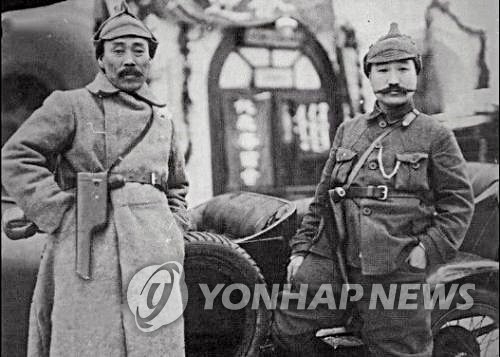 ▲ 1922년 1월 모스크바 극동민족대회에 참석한 홍범도 장군(왼쪽)과 최진동 장군이 레닌에게서 선물 받은 권총을 차고 기념촬영을 하는 모습. ⓒ연합뉴스(반병률 교수 제공)