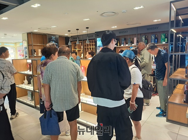 ▲ 주류 매장에 중국 단체 관광객들이 몰려있는 모습.ⓒ조현우 기자