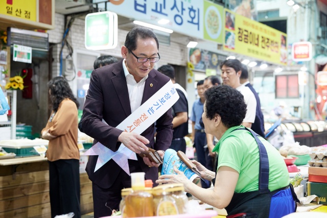 ▲ 경기신보 일일 명예지점장으로 위촉된 김완규 위원장이 전통시장 장보기 가두캠페인을 하고 있다. ⓒ경기도의회 제공