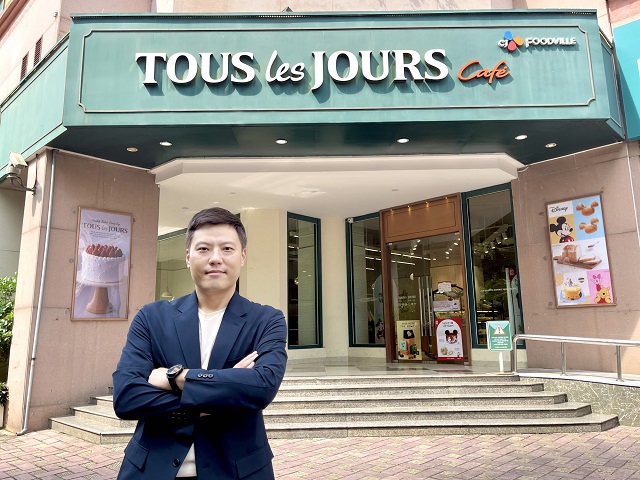 ▲ 김민배 CJ푸드빌 베트남북부 지사장이 매장 앞에서 포즈를 취하고 있다. 뒷편으로 디즈니 IP를 활용한 제품을 홍보하는 포스터가 부착돼있다.ⓒCJ푸드빌