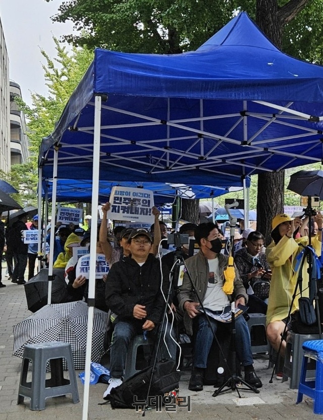 ▲ 이재명 더불어민주당 대표 지지자들이 26일 법원로 옆길에서 '민주주의를 지켜내자'라고 적힌 플래카드를 들고 있다. ⓒ임준환 기자