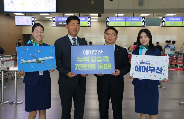 27일 부산 김해공항에서 에어부산 관계자들이 누적 탑승객 7000만명 기념 촬영을 하고 있다. ⓒ에어부산