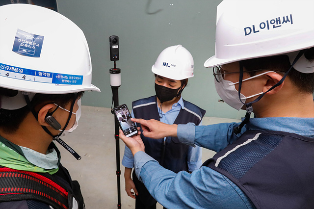 ▲ DL이앤씨 직원들이 360도 카메라로 촬영한 공동주택 건설현장의 시공 품질을 점검하고 있다. ⓒDL이앤씨