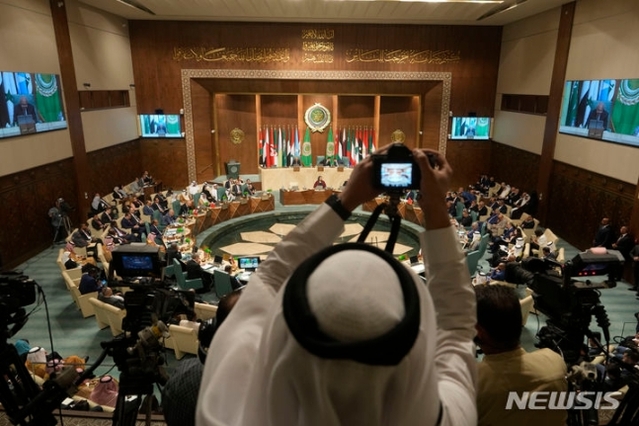 ▲ 이-팔 전쟁의 시급한 정전 문제를 논의하는 10월 11일의 아랍 연맹 22개국 외무장관회의에서 한 참석자가 회의장 사진을 촬영하고 있다. ⓒAP/뉴시스