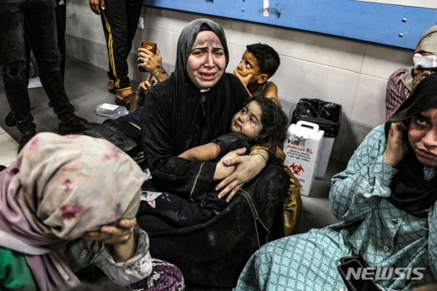 ▲ 팔레스타인 가자지구 내 알 아흘리 병원이 로켓 공격을 받아 수백 명의 사상자가 발생한 17일(현지시간) 팔레스타인인들이 병원 복도에 앉아 통곡하고 있는 모습. ⓒAP/뉴시스