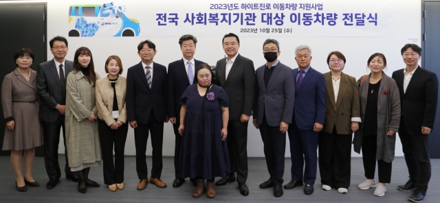 ▲ 25일 김인규 하이트진로 대표이사(오른쪽 여섯 번째)와 사회복지기관 대표 및 관계자가 참석한 가운데 이동차량 전달식이 진행됐다.ⓒ하이트진로
