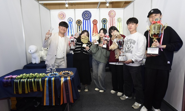 ▲ 영진 반려동물과 학생들이 올해 각종 대회 입상 트로피를 들고  포즈를 취했다.ⓒ영진전문대