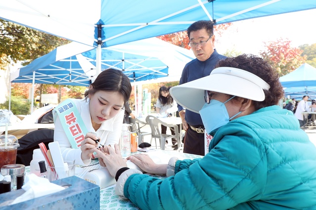 ▲ 행사에 참여한 시민이 네일아트를 받고 있다.ⓒ영남이공대