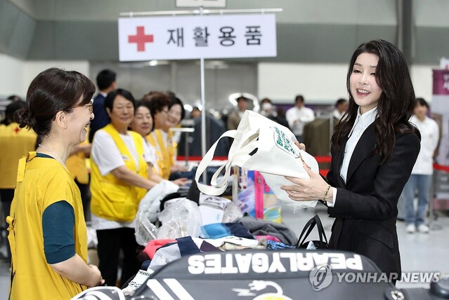 ▲ 윤석열 대통령 부인 김건희 여사가 31일 서울 강남구 코엑스에서 열린 2023 적십자 바자 행사에서 재활용 물품 판매부스를 방문, 구입한 옷을 '바이바이 플라스틱' 에코백에 전달받고 있다.ⓒ연합뉴스(사진-대통령실통신사진기자단)