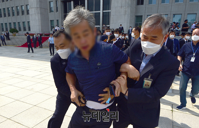 ▲ 청와대 경호원 및 국회 경위들이 지난 2020년 7월16일 오후 국회에서 열린 제21대 국회 개원식에 참석해 개원 축하 연설을 마친 문재인 대통령을 향해 신발을 던지고 규탄 구호를 외친 남성을 끌어 내고 있다. ⓒ이종현 기자